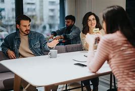 Diverse group of colleagues having a relaxed conversation in a cozy cafe